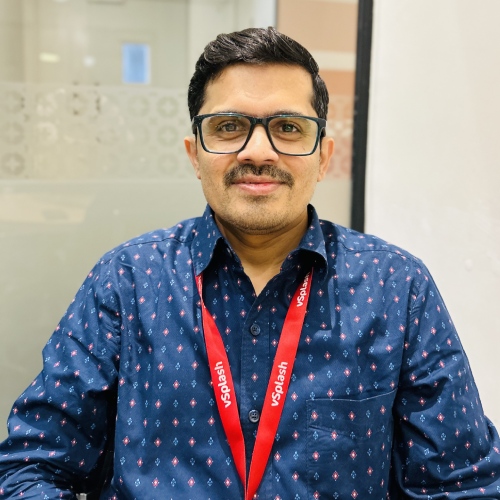 Man wearing glasses and blue shirt with red lanyard.