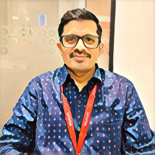 Man wearing glasses and blue patterned shirt.