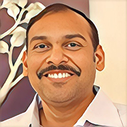 Smiling man with mustache and white shirt.